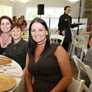 Woman in polka dot dress smiling at indoor event